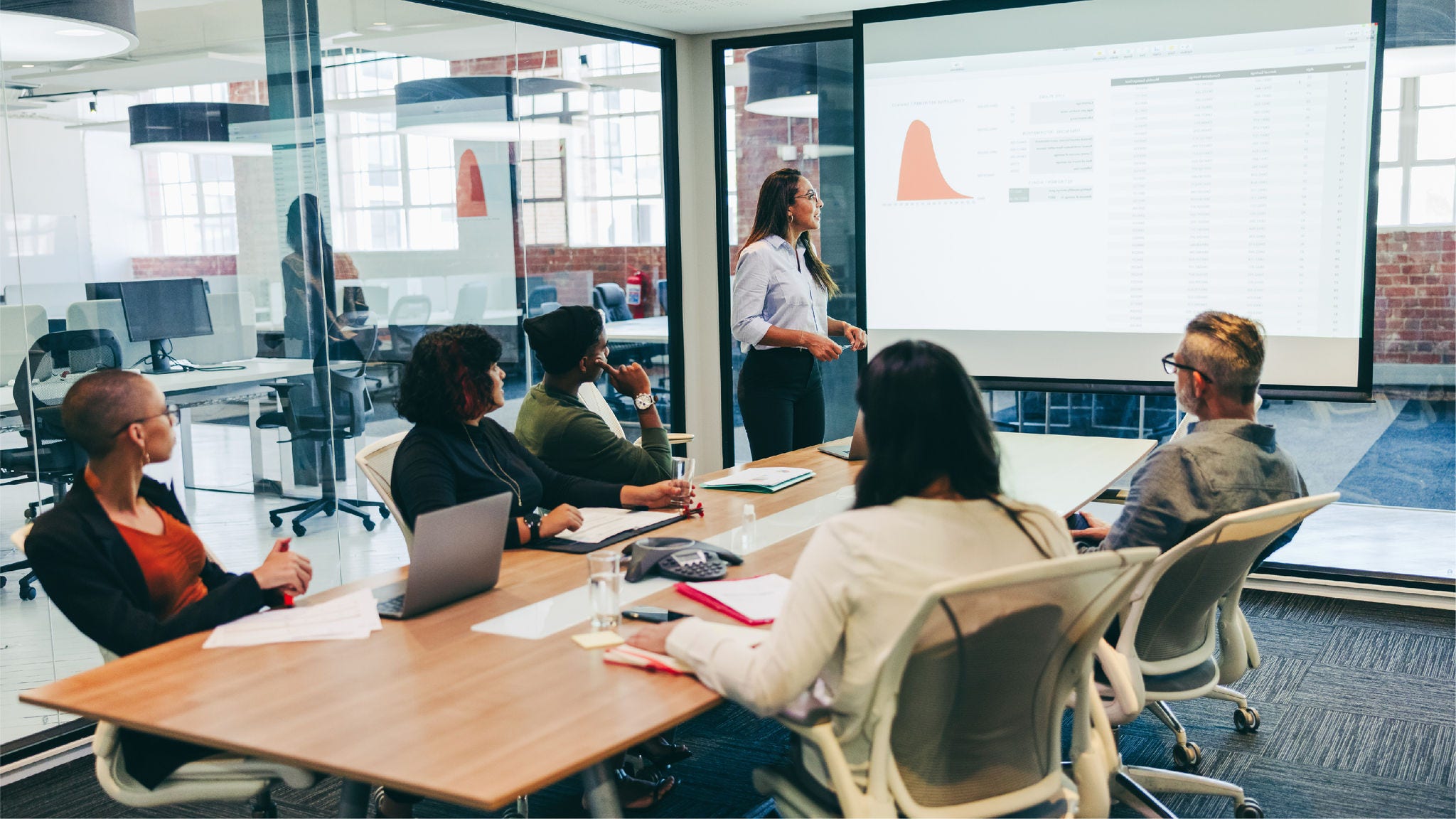 Group of employees in conference room looking at presentation Group of employees in conference room looking at presentation