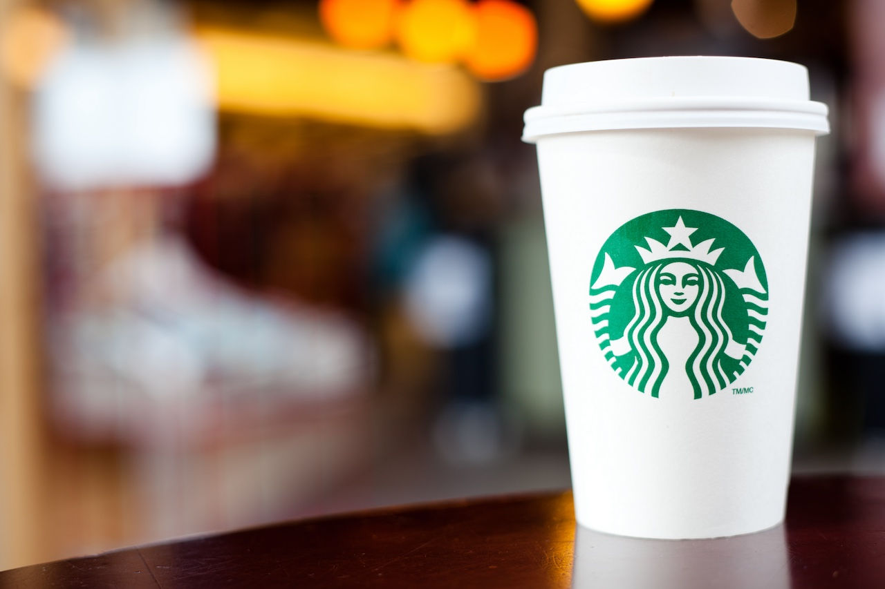 A Starbucks paper cup with the chain's logo on it.